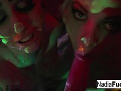 Blacklight babes Nadia White and Ophelia take turns sucking on a colorful penis