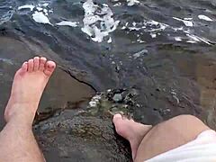 أقدام ميكا الكبيرة والشعرية تستمتع باللعب حافي القدمين في الماء