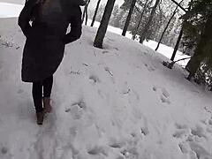 Ξανθιά γυναίκα και σύντροφος απολαμβάνουν το χιόνι
