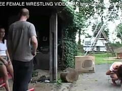Twee meiden doen mee aan een worstelwedstrijd op een autokerkhof