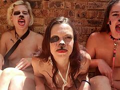 Drie naakte vrouwen houden zich bezig met kinky tongspel buiten