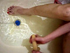 Heißer Footjob und Spielzeugspiel an nackten Füßen in der Badewanne